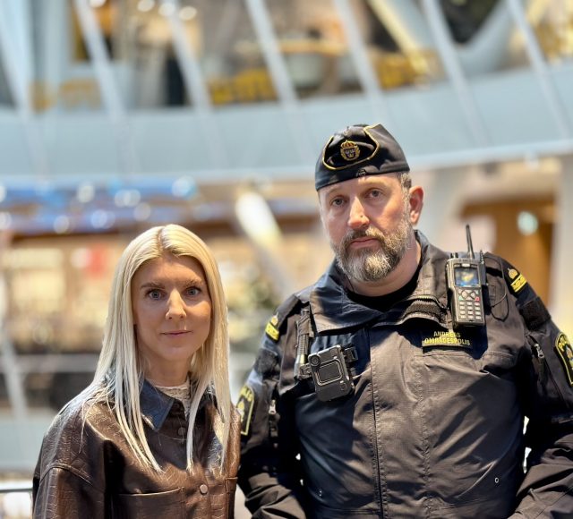 Sandra Linder, marknadsansvarig kvarteret Utopia tillsammans med polisen Andreas. I bakgrunden ser man kvarteret Utopias atrium.