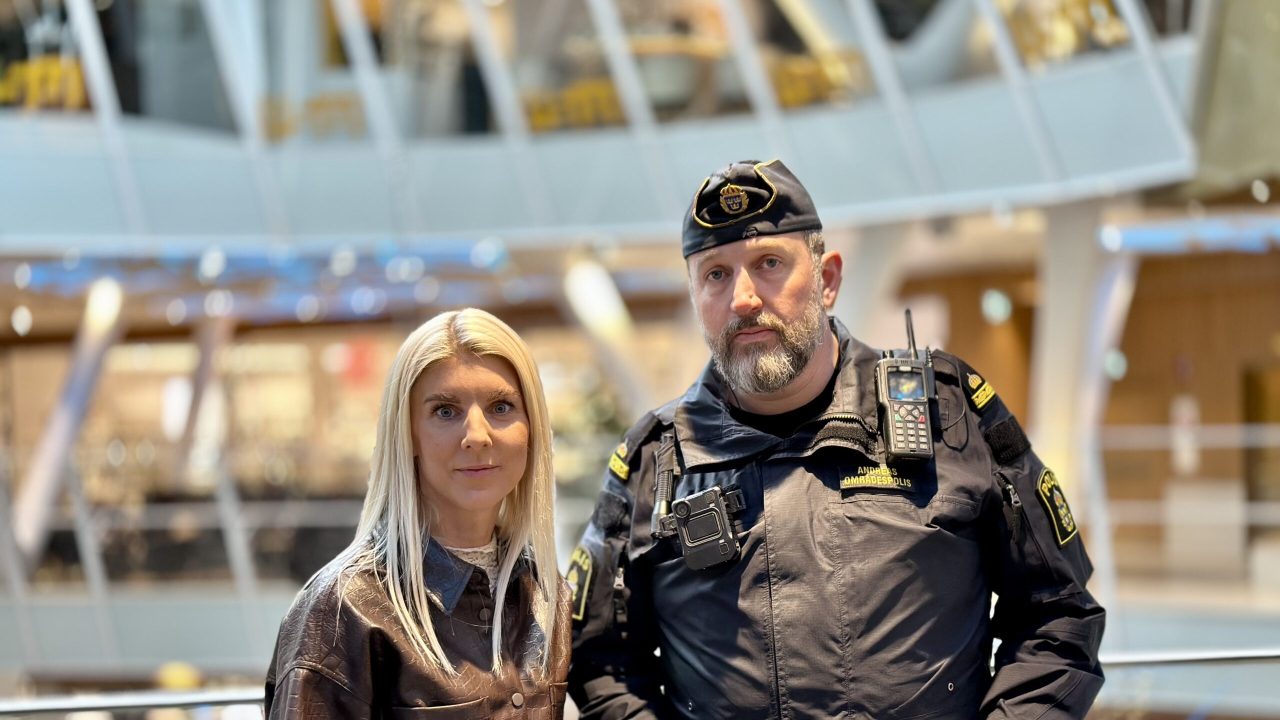 Sandra Linder, marknadsansvarig kvarteret Utopia tillsammans med polisen Andreas. I bakgrunden ser man kvarteret Utopias atrium.