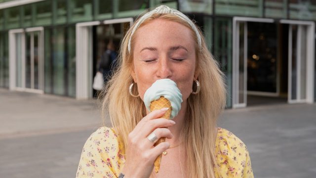 Tjej njuter av en svalkande glass utanför kvarteret Utopia.